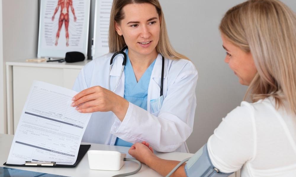 Primary care physician explaining blood pressure numbers during a wellness exam in Round Rock TX