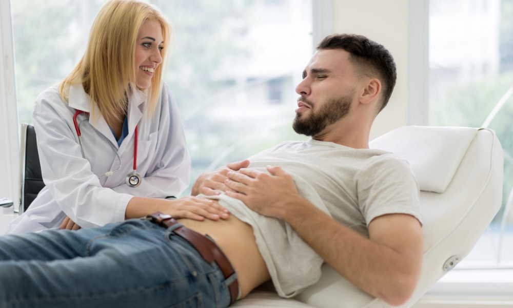 Primary care doctor discussing common causes of abdominal pain with an adult patient in Round Rock TX